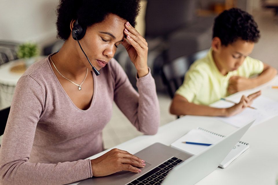Stressed woman working from home with children